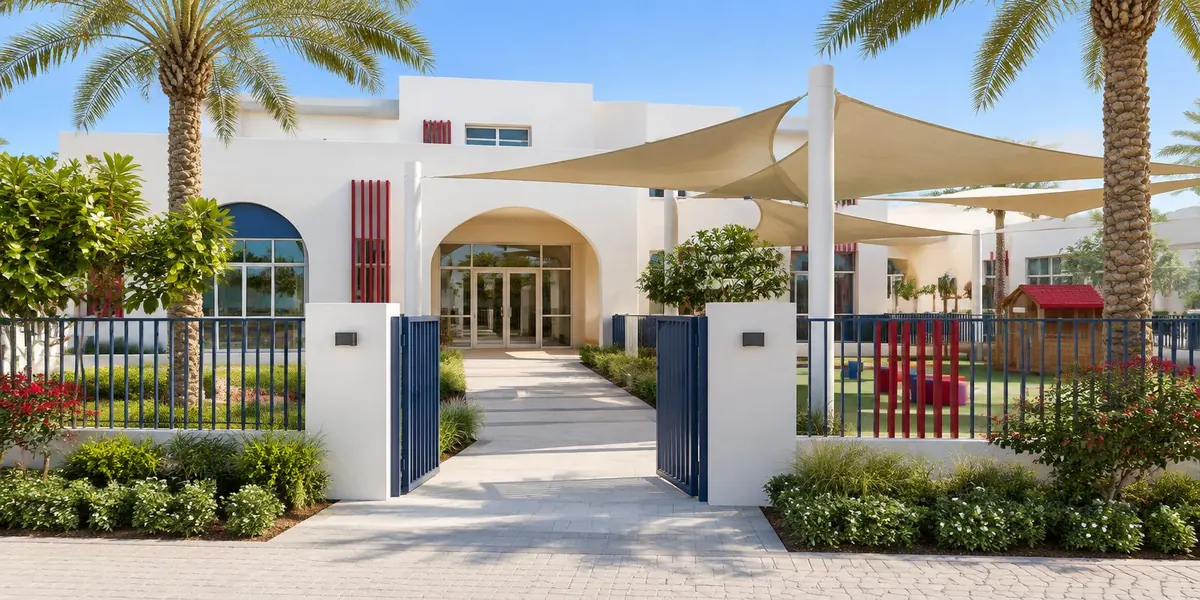 Sunny white nursery building with a gate, garden path, palm trees and shade sails